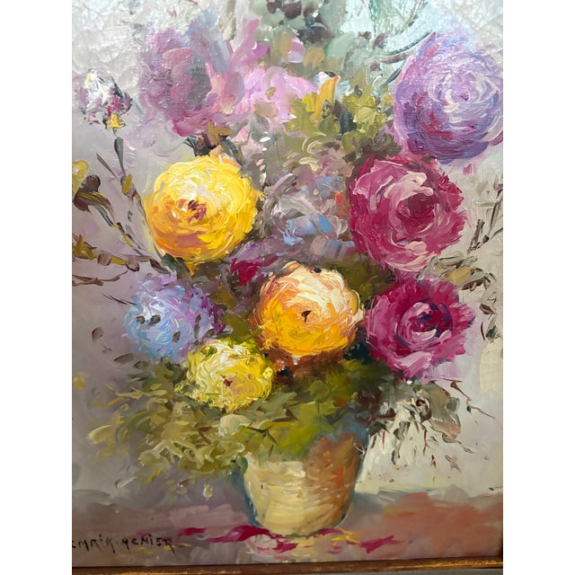 An original oil painting on canvas featuring a vibrant floral still life of ranunculus signed by listed French artist...