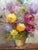 An original oil painting on canvas featuring a vibrant floral still life of ranunculus signed by listed French artist...