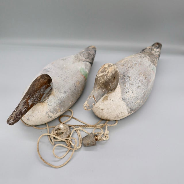 A pair of true working duck decoys, carved in wood and hand-painted, with their anchor lines and weights still attached....