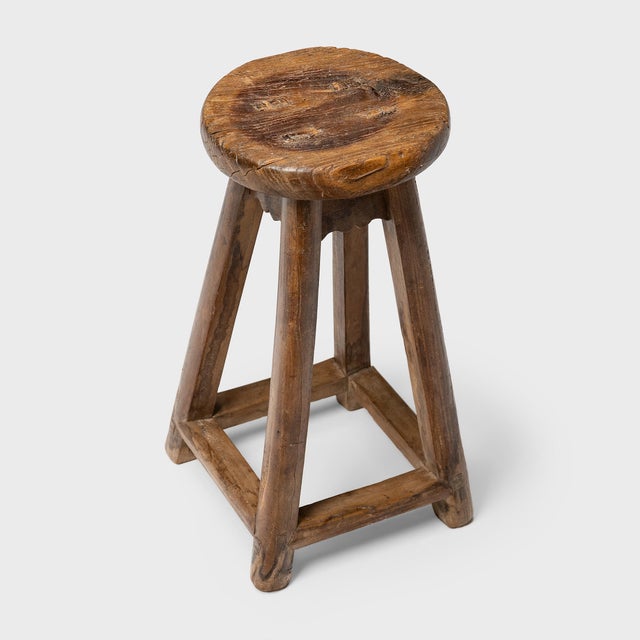 This rustic wooden stool from China's Shanxi province charms with its compact scale and timeworn texture. Crafted with...