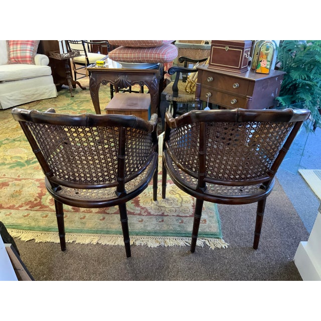20th century pair of cane seat chairs. Chinoiserie faux bamboo with brown speckled finish. Wide comfortable seat comes...