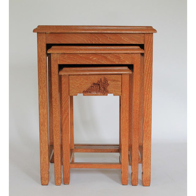 Set of three nesting tables with hand carved wood, soapstone and painted Asian figures. Small table has a single drawer....