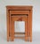 Set of three nesting tables with hand carved wood, soapstone and painted Asian figures. Small table has a single drawer....