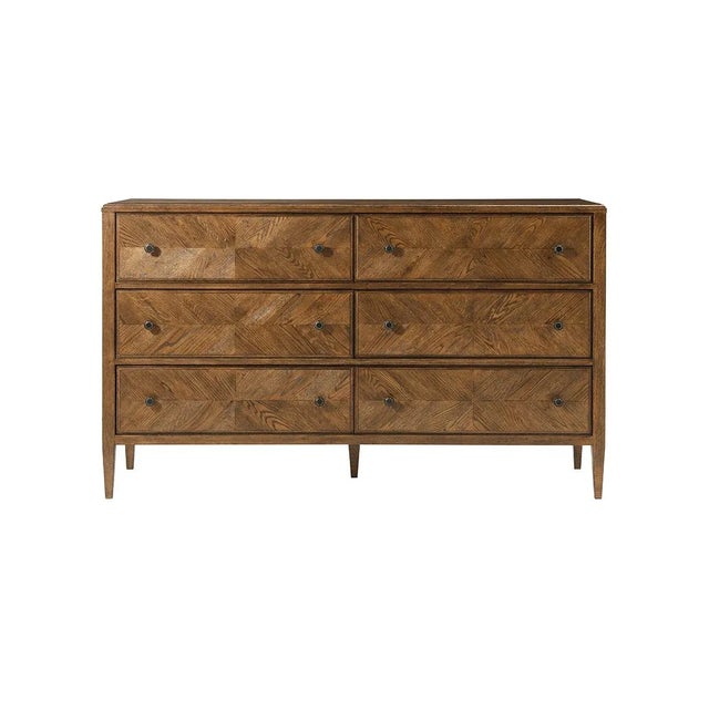 A dark rustic-style dresser with six hand-veneered drawers accented with Verde Bronze finish handles and tapered oak legs....