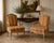 A charming pair of Louis XV style bergere armchairs featuring carved frames, cabriole legs, and warm striped upholstery in...