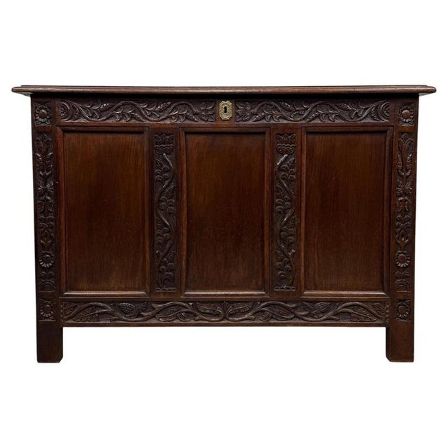 A handsome 19th-century English coffer, finely crafted from oak and distinguished by its richly carved façade, substantial...