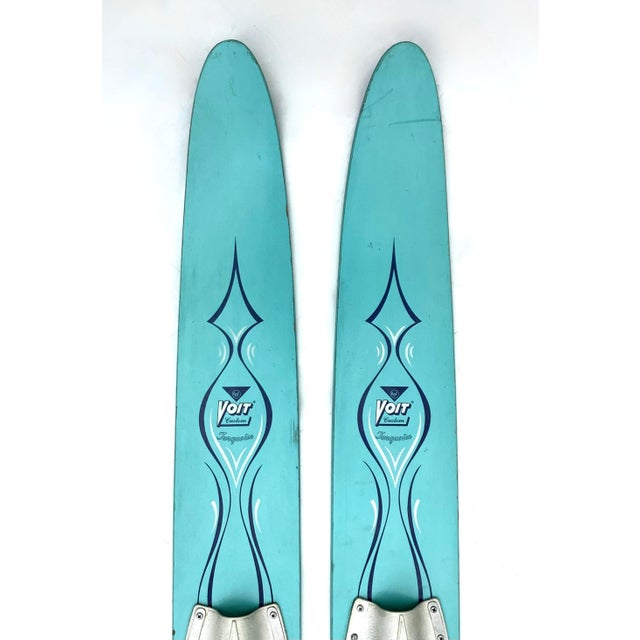 A pair of vintage Voit Turquoise wood water skis with original navy blue and white graphics. Water skis have original...