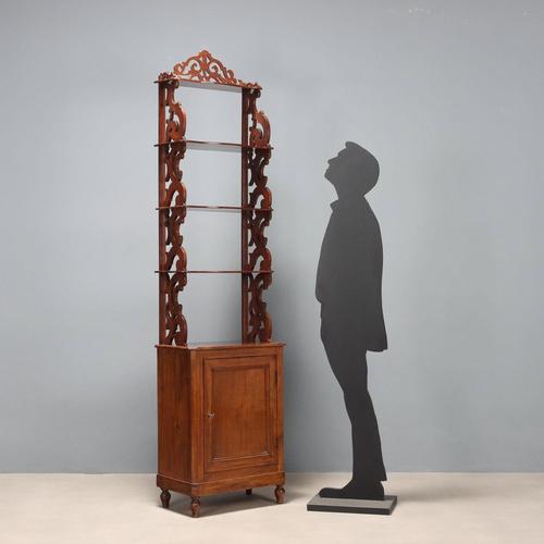 Mahogany etagere. Central doors at the base, surmounted by four shelves supported by perforated and scrolled side...