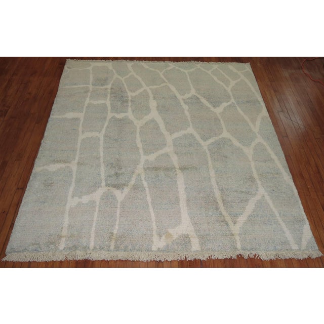 A piled Turkish rug with a motif resembling New Production rugs woven in Tibet. Colors in gray and ivory with a soft green...