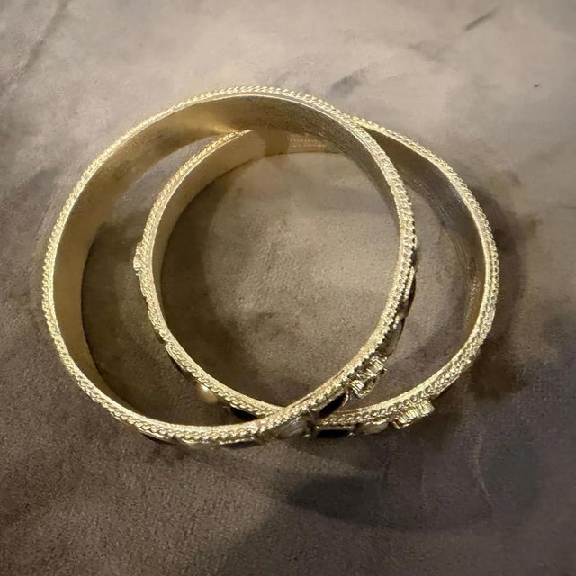 This rare duo of Chanel bangle bracelets captures the bold, high-contrast glamour of the 1990s. Crafted in heavy gold-...