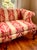 Chippendale-style camelback sofa with scrolled arms and carved cabriole legs ending in claw-and-ball feet. Upholstered in...