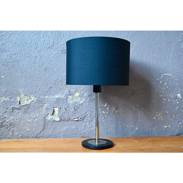 Minimalism and modernity are the key words to describe this 1970s lamp. Made of chrome and black metal, this table lamp...