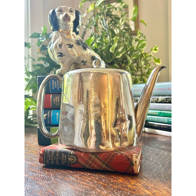 This piece is an antique British silverplate teapot by the Sheffield maker Walker & Hall, engraved with the regimental...