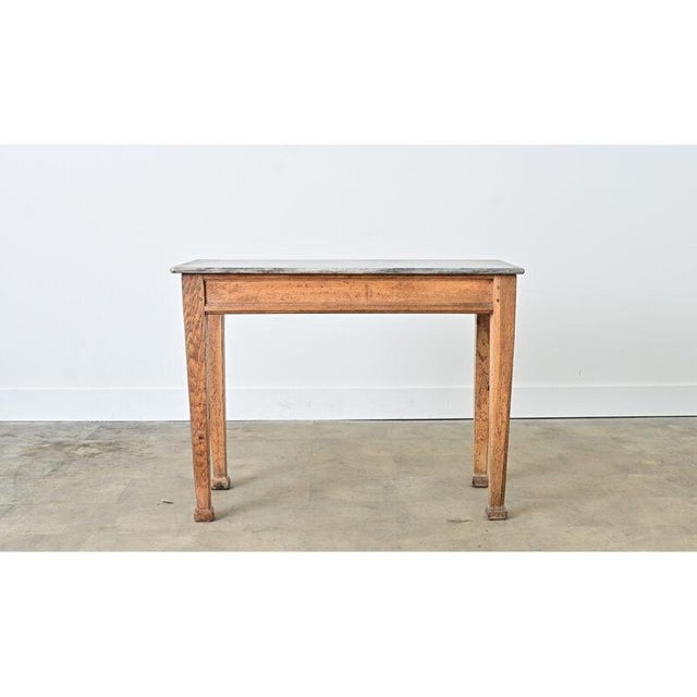 Dating to circa 1870, this 19th-century butcher shop or bakery display table features a patinated gray marble top on an...