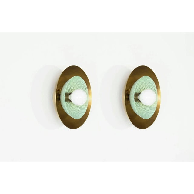 The Centric wall sconce is a stately take on French modernism, featuring a spun metal mesh shade nestled into a large...