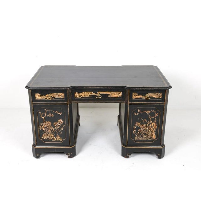 Stunning chinoiserie desk with lustrous black lacquer finish glows with intricate hand painted gilt accented and Asian-...