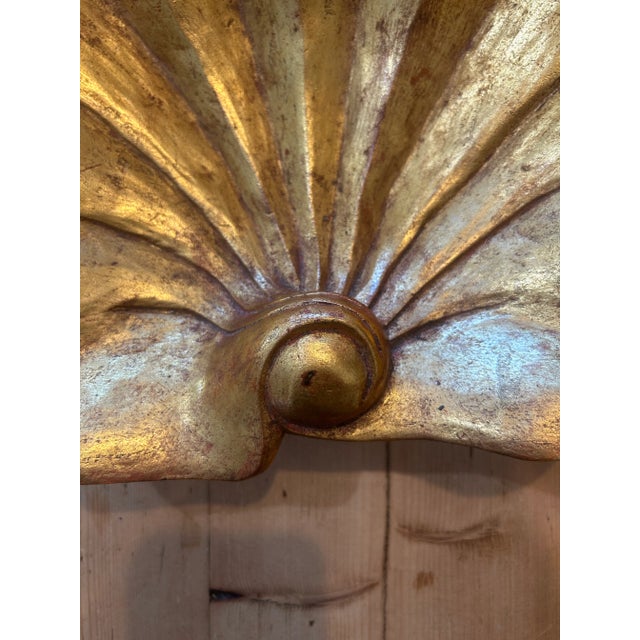 A luminous vintage papier-mâché bowl hand formed in the shape of a scallop shell, finished in rich layers of gilt and...