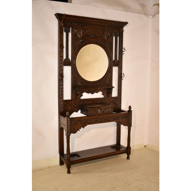 19th century oak hall stand from England. The top has a lovely crown molding, over a hand carved central panel, flanked by...