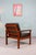 Two Danish teak armchairs made of solid wood with brown leather upholstery. Designed by Sven Ellekaer, manufactured by...