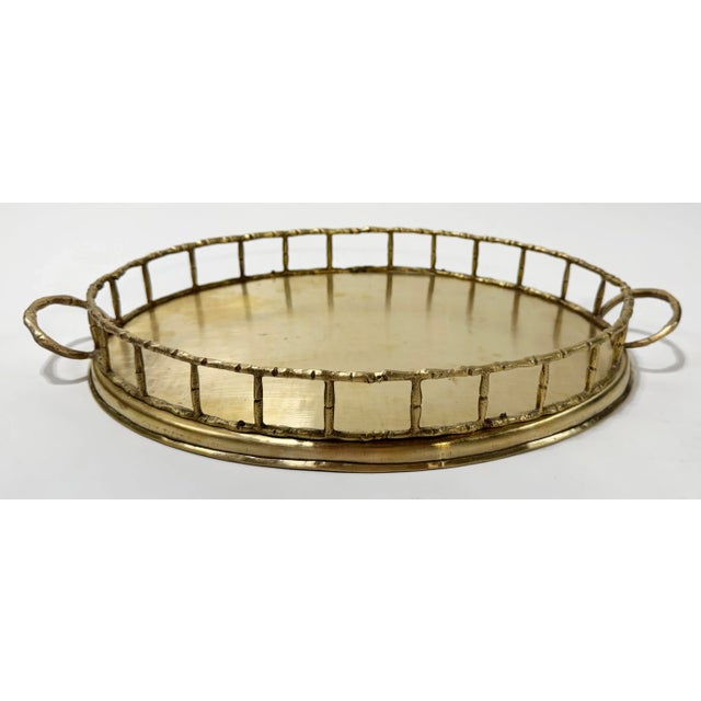 Large vintage brass tray featuring faux bamboo detail to rail and handles. Classic oval shape. Lovely patina. 33