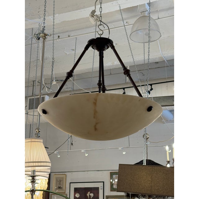Design Plus Gallery presents a Hanging Pendant with a Faux Alabaster Bowl. This fixture has an inverted dish design...