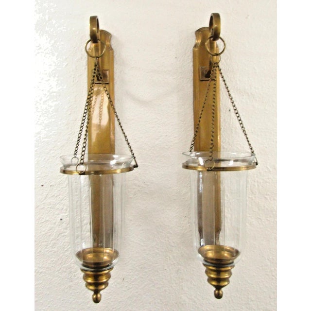 The Antique Brass Hurricane Wall Sconce Pair attributed to Virginia Metalcrafters is a set of two stylish and elegant...