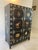 Beautiful antique black Chinoiserie cabinet adorned with hand-painted decorative shells and designs of various pots and...