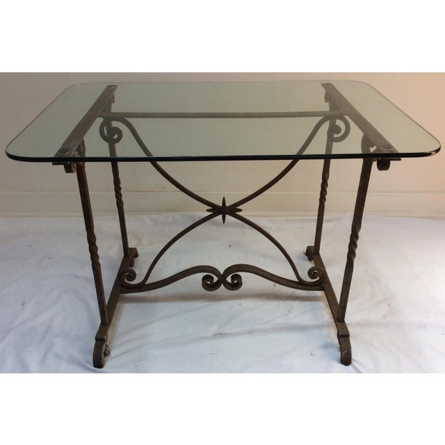 Great looking unusual hand wrought iron table base with modern glass top. The glass top has some scratches. The base came...