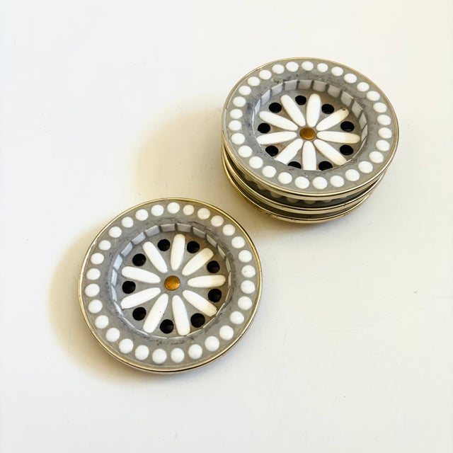 A wonderful set of 4 mid century mosaic coasters. Each is made using pieces of white and black ceramic, set in gray...