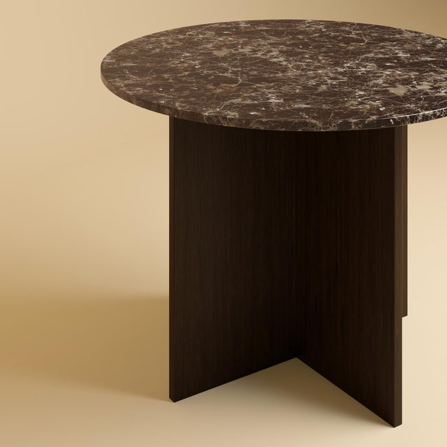 The Dalma is an Emperador Dark marble and oak dining table, a table scaled for a room and its company in which a marble...