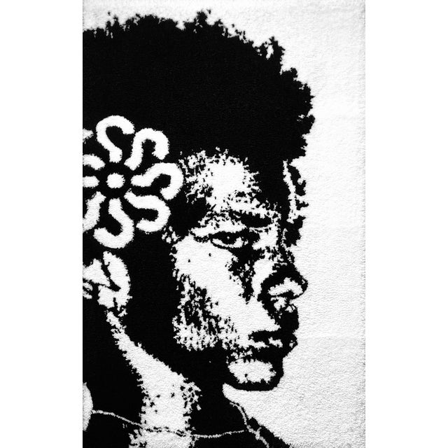 Rendered entirely in black and white, this piece is immediate and high-contrast: a face emerges from curling, looping...
