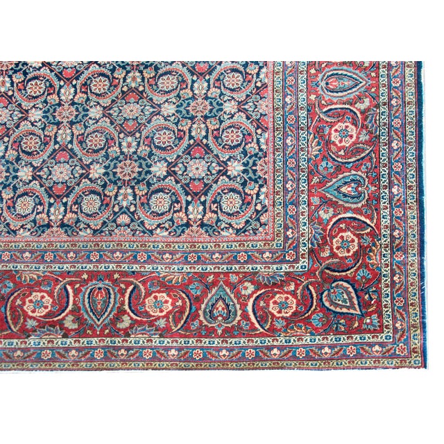 A fantastic early 20th century Persian Kashan rug with an all-over trellis floral pattern with myriad flowers, leaves, and...