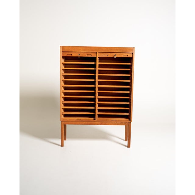 Oak cabinet with double roller shutter, locks, and numerous pull-out shelves arranged across two sections. Swedish...