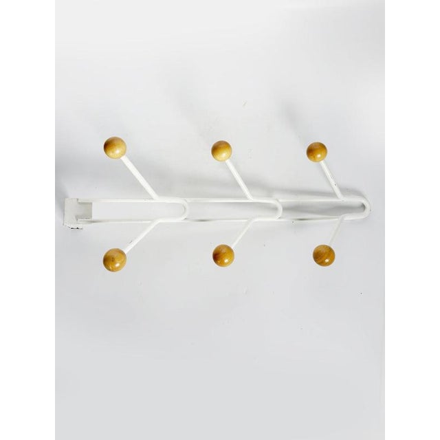 Vintage French wall-mounted coat rack dating from the 1990s, combining a white-painted metal structure with natural wooden...