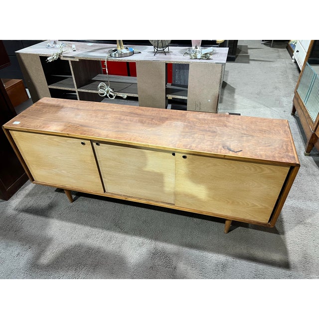 A beautifully proportioned Mid-Century Modern media console crafted in warm teak wood, showcasing clean lines and...