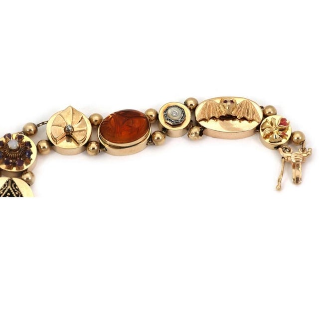 This authentic vintage slide charm bracelet is crafted in solid 14k yellow gold and features ten beautifully designed...