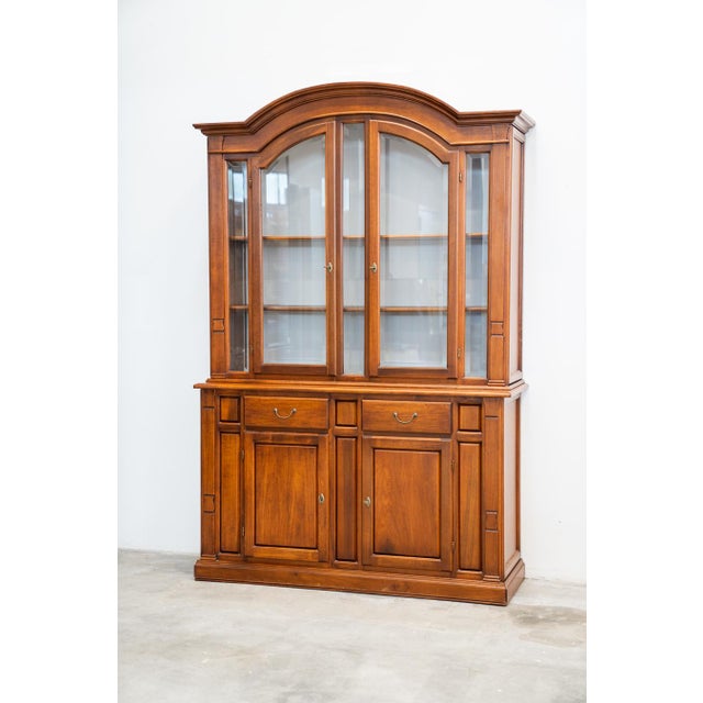 It is composed of two pieces of carved beech wood furniture, walnut colour. Brass handles. The doors are made of glass...