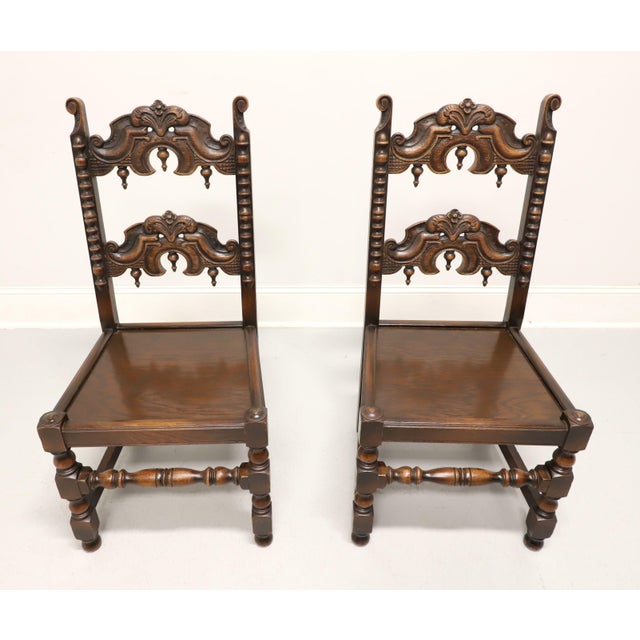 An antique pair of Gothic Revival style dining side chairs by Grand Rapids Bookcase and Chair Company. Solid oak with...