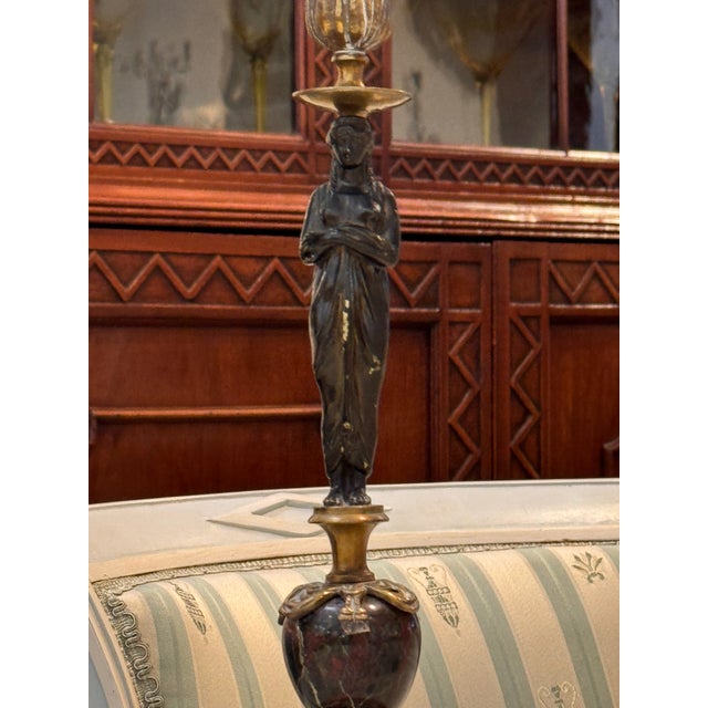 A elegant French Empire candlestick lamp combining patinated bronze and marble in a well-composed neoclassical...