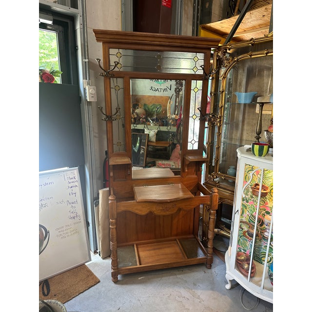 Up for consideration is a beautiful vintage 1970s mid-century modern wooden and stained glass hall tree with brass...