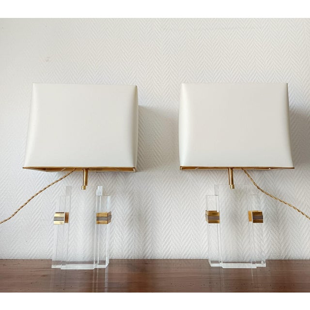 Pair of Hollywood Regency style lamps, circa 1970/1980. Rectangular acrylic glass lamps with geometric brass and silver-...
