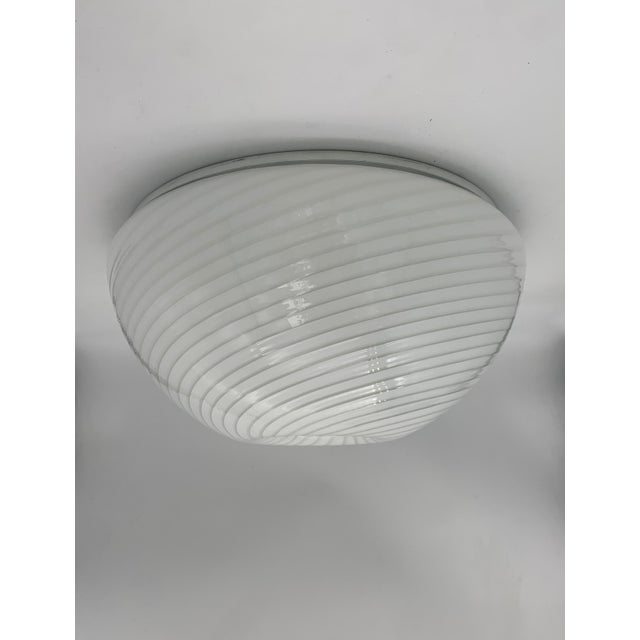 Ceiling lamp with an elegant and contemporary design, crafted from milk glass with a refined spiral pattern that creates a...