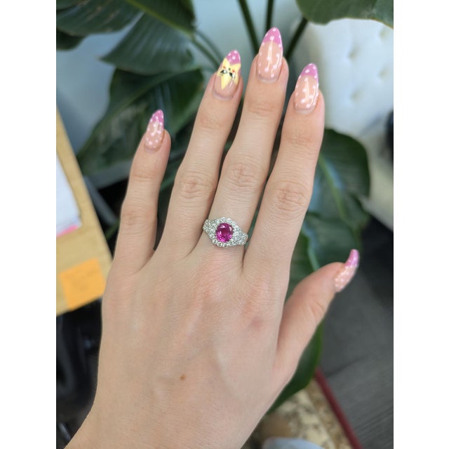 Bold and unforgettable, this 2ct hot pink oval sapphire ring is set in solid 14K gold and framed with natural diamond...