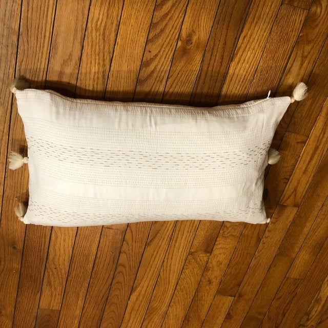 Very adorable ivory white with gray beige bolster pillow with tassels on the sides