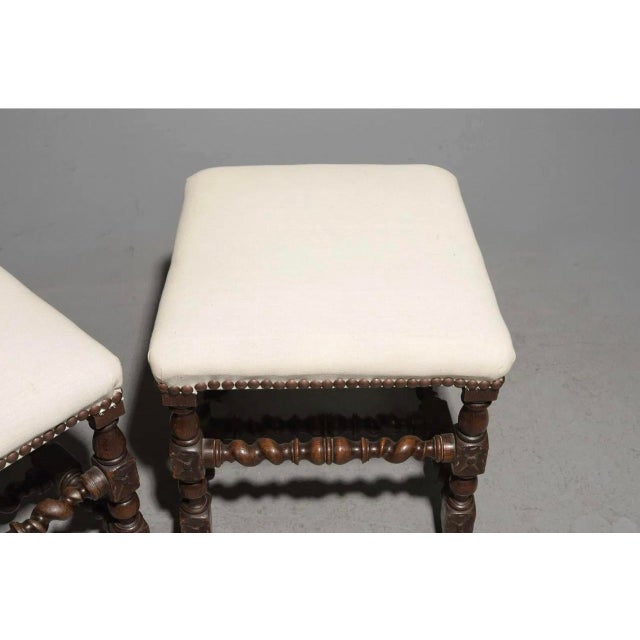 A striking pair of Louis XIII–style French stools crafted in richly toned solid oak, embodying the bold, architectural...