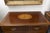 An elegant Federal-style mahogany chest of drawers, featuring a beautifully figured top centered by an oval satinwood and...