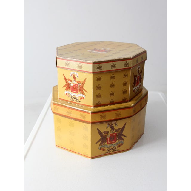 These vintage Knox hat boxes, dating from the 1940s to 1950s, feature an eye-catching octagonal design with a rich gold...