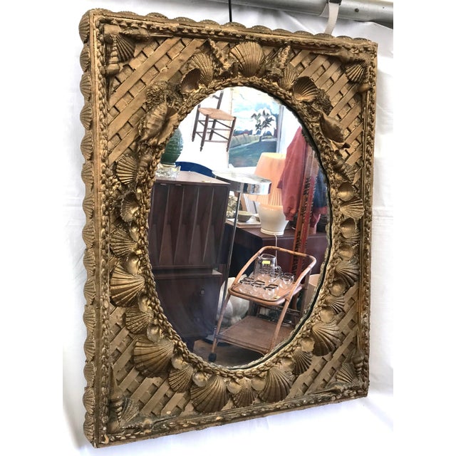 Fabulous vintage c.1980's Coastal Chic / Hollywood Regency bronzey gold painted shell mirror! The mirror is constructed...