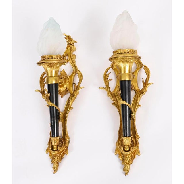This is a superb pair of stylish French Rococo revival ormolu & glass flaming torch wall lights, circa 1900 in date. Each...