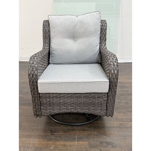 Design Plus Gallery presents an Outdoor Porch Glider Swivel Chair. The chair has a woven wicker-style frame with rolled...